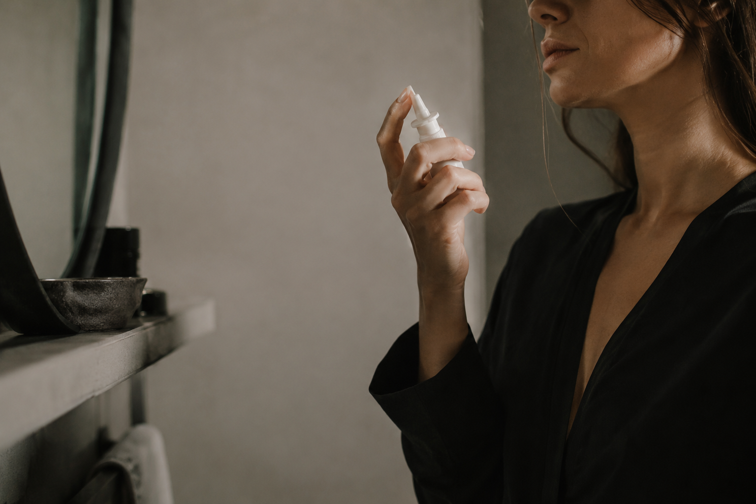 Person holding a nasal spray bottle